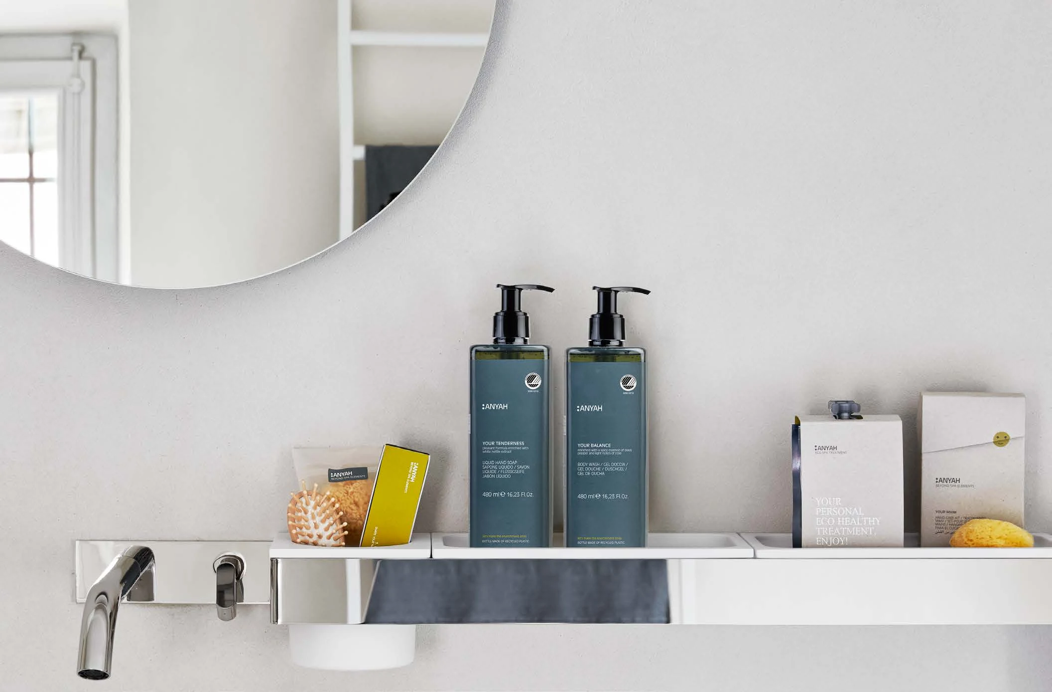Dispenser Anyah coordinati su una mensola di un bagno luminoso