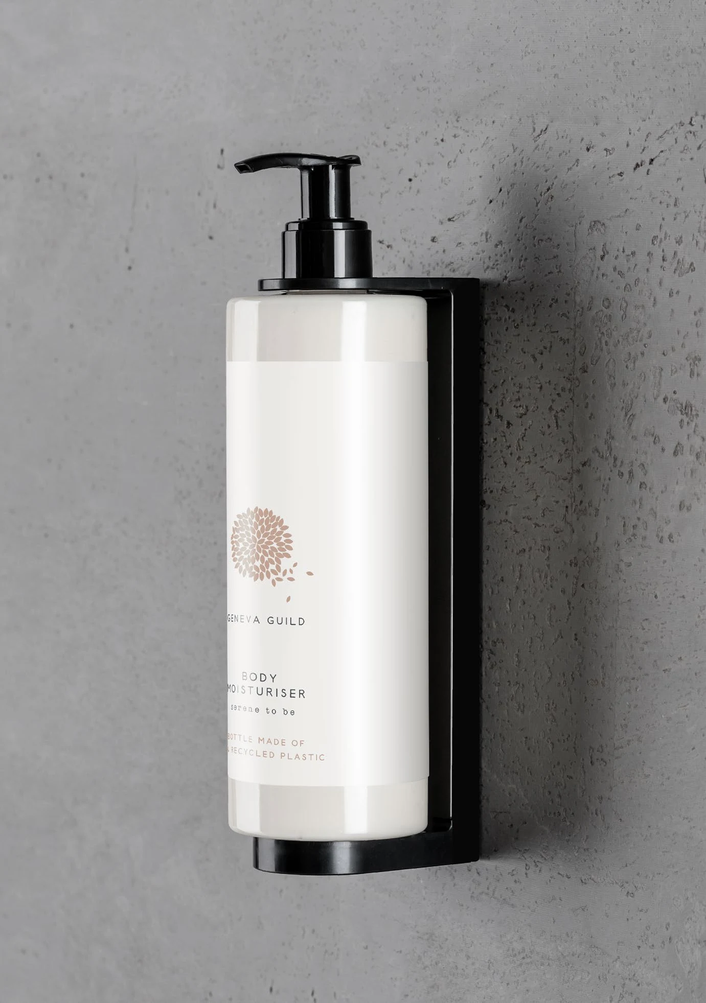 Dispenser Geneva Guild con pompa nera installato su parete grigia