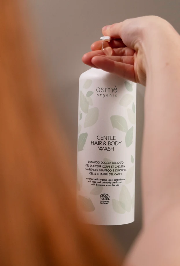 Persona che utilizza un dispenser Osmè tenendolo in mano
